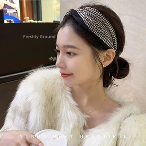 Detail of a chic black and white houndstooth headband with a stylish center twist design