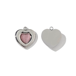 Macro detail of heart-shaped pendant with pink stone and polished stainless steel back