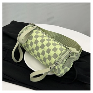 Detail view of checkerboard barrel bag with wide strap and textured fabric finish