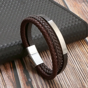 Close-up of dark brown woven leather bracelet with polished silver metal buckle on a desk