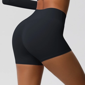 Detail view of high-waisted black yoga shorts showing slimming and lifting effect on model