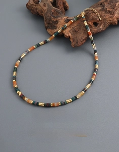 Detail of colorful stone beaded necklace with gold disc spacers and lobster clasp closure