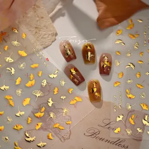 Close-up of M1247 gold ginkgo leaf nail stickers with metallic foil finish for autumn manicures