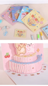 Detail view of 3D pop-up birthday card with cute bear and pink cake design