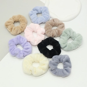 Gros plan de chouchous en fausse fourrure de lapin en 9 couleurs sur plateau blanc