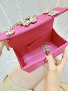 Detailed interior of rose pink velvet clutch showing rhinestone buckle and silver chain strap