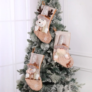 Three premium sequined Christmas stockings with Reindeer Santa and Snowman hanging on a tree