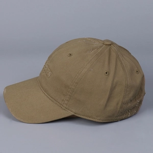 Detail of distressed brown cotton baseball cap with torn edges and vintage frayed textures