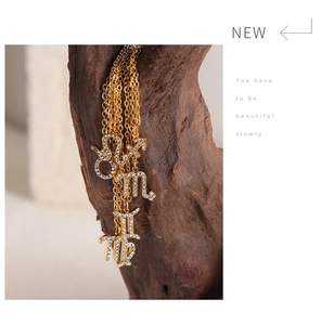 Close-up of golden zodiac necklaces with inlaid rhinestones on a wooden stand