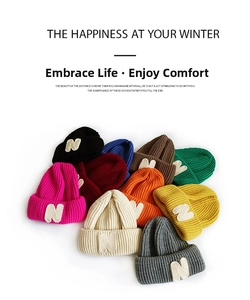 Detail of colorful knitted beanies with plush N patch showing thick material and textures