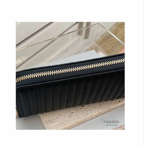 Close-up of black PU leather wallet featuring vertical quilting and premium gold zipper detail