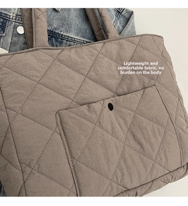 Close-up of taupe quilted tote bag featuring classic diamond stitching and matte metal snap button