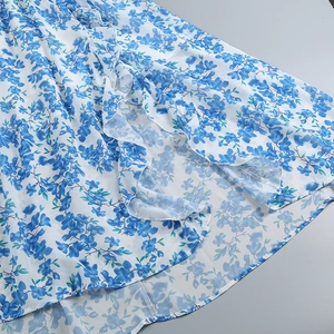 Detail of floral dress hem with blue floral print and elegant layered ruffle edge