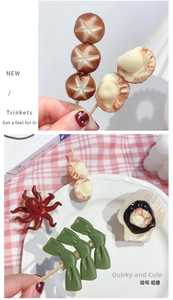 Detailed close-up of realistic resin food hair clips showing scallops and octopus designs