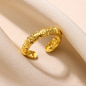 Detailed view of adjustable gold ring with embossed floral pattern and beaded textures