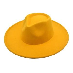 Detail of a ginger yellow wool felt fedora hat featuring a wide brim and teardrop crown