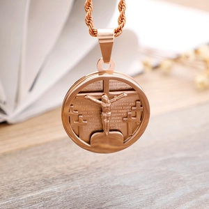 Macro detail of rose gold pendant with crucifix and engraved Spanish Lord's Prayer