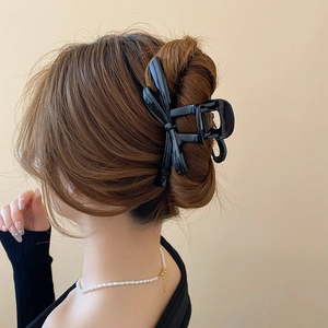 Elegant large black bow hair claw clip styled on a French twist hairstyle
