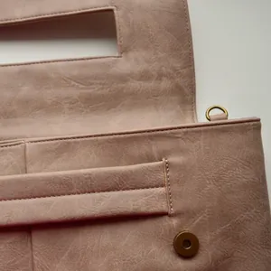 Macro shot of dusty rose PU leather texture with lychee grain and magnetic closure