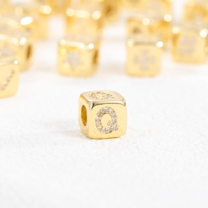Macro view of 18k gold plated cube pendant with zircon-inlaid letter Q detail