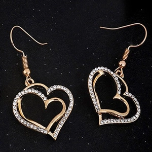 Macro shot of gold double heart earrings with crystal pavé on black background