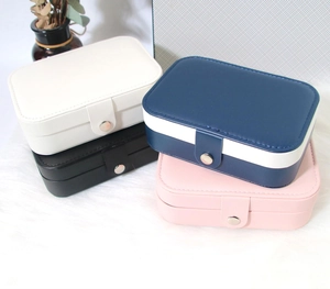 Stack of four portable jewelry organizers in white, black, blue, and pink faux leather