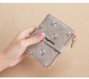 Close-up of grey short PU leather wallet with white floral print and snap button detail
