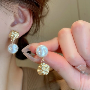 French style irregular gold metal earrings with faux baroque pearls on a model