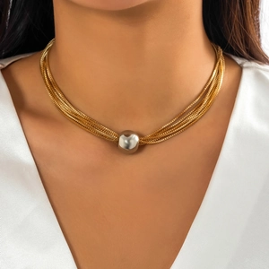 Detail of layered gold metal chains with a large polished silver spherical pendant