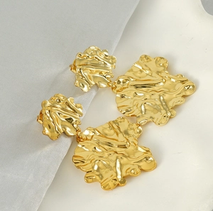 Macro view of 18K gold plated stainless steel irregular lava leaf earrings with hammered texture