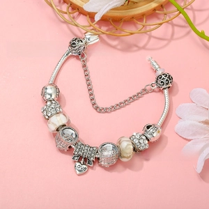 Detailed shot of silver charm bracelet with LOVE heart pendant and safety chain