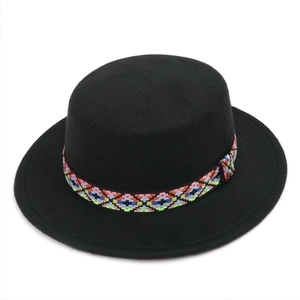 Close-up of a black flat-top wool felt hat featuring a colorful geometric embroidery band