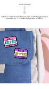 Detail of She/Her and They/Them enamel pronoun pins attached to a blue canvas fabric bag