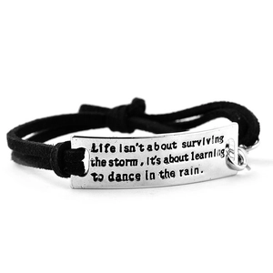 Detail shot of black braided rope bracelet with engraved silver inspirational quote plate