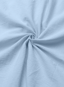 Macro shot of light blue cotton linen fabric showing natural pleated texture and drape