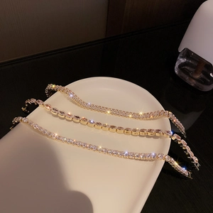 Detailed shot of gold cubic zirconia bracelets in round, oval, and emerald cut styles
