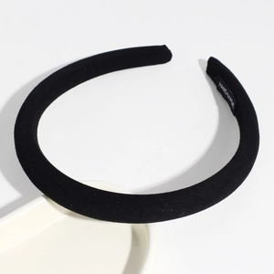 Detail of minimalist black headband with woven texture and handmade interior label
