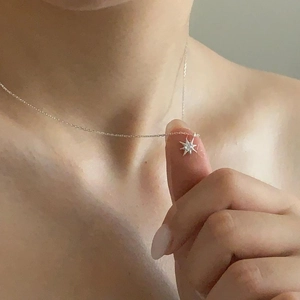 Macro shot of a 925 silver starburst pendant with zircon on a delicate necklace chain