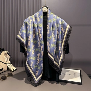 Detail view of a luxury blue silk square scarf with vintage carriage print on a hanger