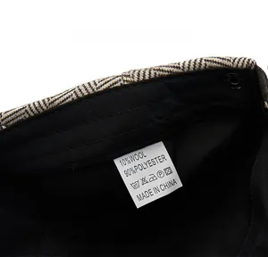 Detail view of newsboy cap care label showing 10% wool and 90% polyester blend fabric