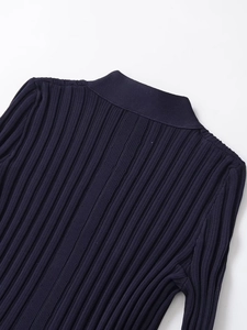 Detail of dark blue ribbed knit fabric showing vertical stripe texture and neck stitching