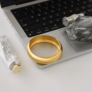 Detail eines 18K vergoldeten Edelstahlarmreifs mit matter Satin-Metallstruktur