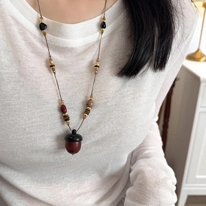 Ethnic acorn pendant necklace with stone and wood beads on a vintage long sweater chain