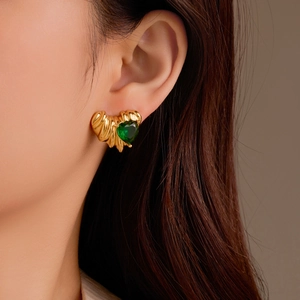Boucles d'oreilles cœur plaquées or 18 carats avec zircon vert portées sur modèle
