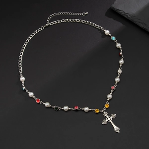Detail of silver chain necklace with white pearls, multi-colored gems, and cross pendant