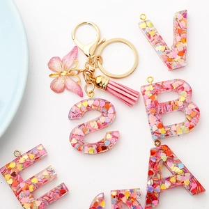 Resin alphabet keychain with heart sequins, pink tassel, and butterfly charm set