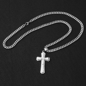 Detailed close-up of a silver stainless steel Cuban link chain with a cross pendant