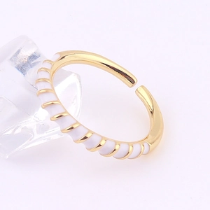 Macro shot of gold and white enamel wave ring on ice cubes with adjustable band detail