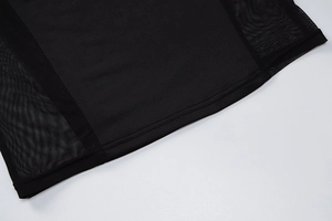 Detailed close-up of black dress hem showing mesh patchwork and reinforced double stitching