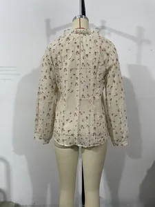 Detailed back view of cream floral blouse with lace stitching and tassel accents